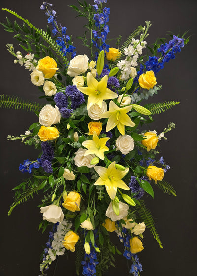 sympathy funeral celebration of life arrangement of yellow, white, blue flowers standing spray 